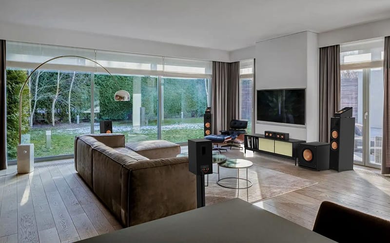 Floorstanding speakers either side of a wall-mounted TV in an open-plan living room
