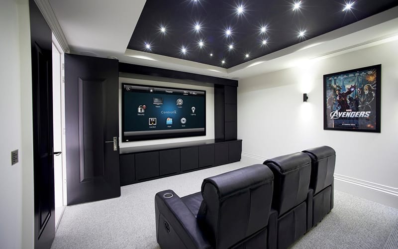 Home cinema room with tiered recliner seating, a star-effect ceiling and a large screen