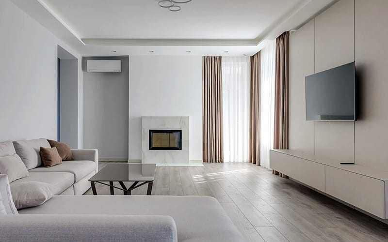 Television mounted flush to a panelled feature wall above a floating cabinet in a modern living room